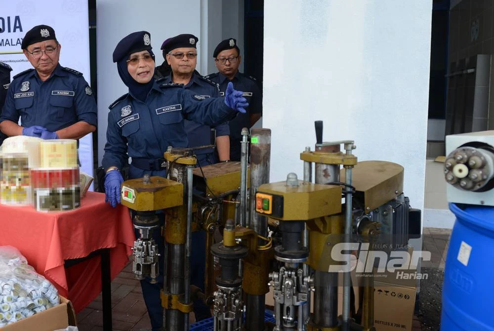 Siti menunjukkan peralatan memproses minuman keras tiruan yang dirampas JKDM pada 15 Oktober lalu. Foto Sinar Harian - MOHD HALIM ABDUL WAHID