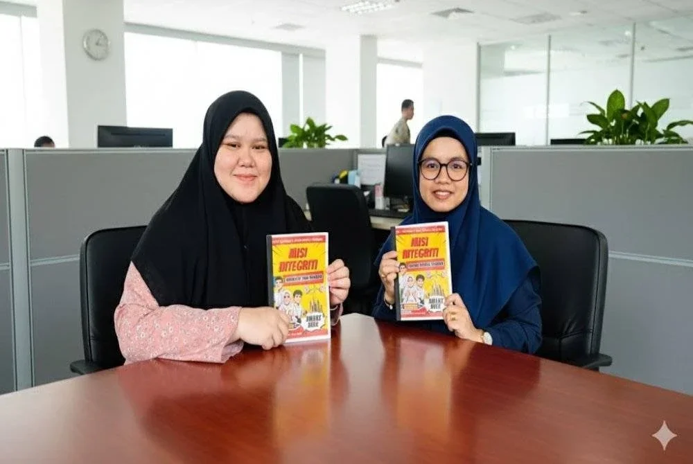 Pensyarah Politeknik Kuching Sarawak, Haslinda Jama'in (kanan) dan Nur Maisarah Syahirah Zainal Abidin bersama komik yang dihasilkan menerusi kerjasama dengan SPRM.