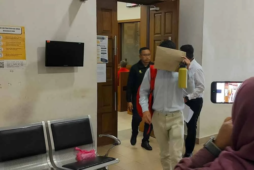 Hock Seong menutup muka ketika keluar dari Mahkamah Majistret Kuantan pada Khamis selepas mengaku bersalah dan didenda kerana menjual produk tembakau bersama barangan sebagai hadiah di stesen minyak di Sungai Ular.