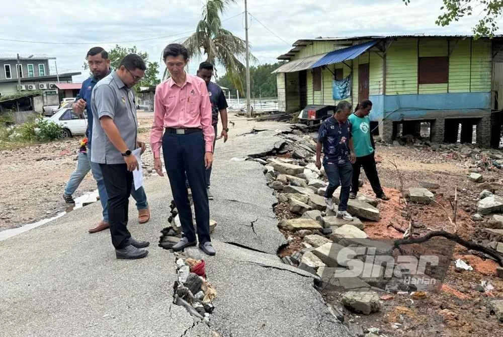 Boon Lye (dua dari kiri) meninjau jalan yang rosak akibat air pasang besar pada Rabu.