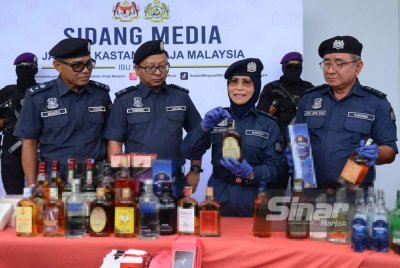 Siti menunjukkan antara botol minuman keras yang dirampas JKDM pada 15 Oktober lalu. Foto Sinar Harian - MOHD HALIM ABDUL WAHID