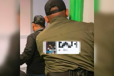 Anggota penguat kuasa menyerbu salah sebuah bilik hotel sebelum menahan pasangan remaja yang berkhalwat. Foto JAINJ