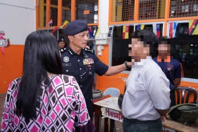 Dzulkhairi (tengah) beramah mesra dengan pelajar sekolah berkenaan.