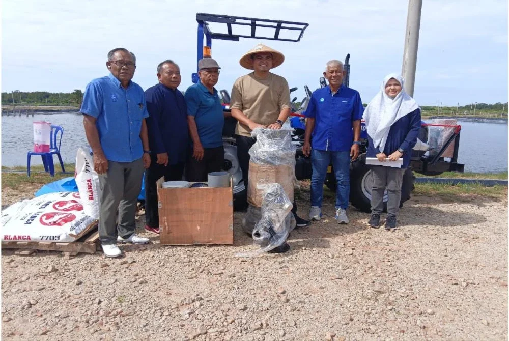 Muhamad Akmal (empat dari kiri) bergambar bersama peruntukan peralatan sokongan seperti traktor yang diterima kepada LKIM Melaka di Kampung Sebatu, Sungai Rambai, pada Jumaat.