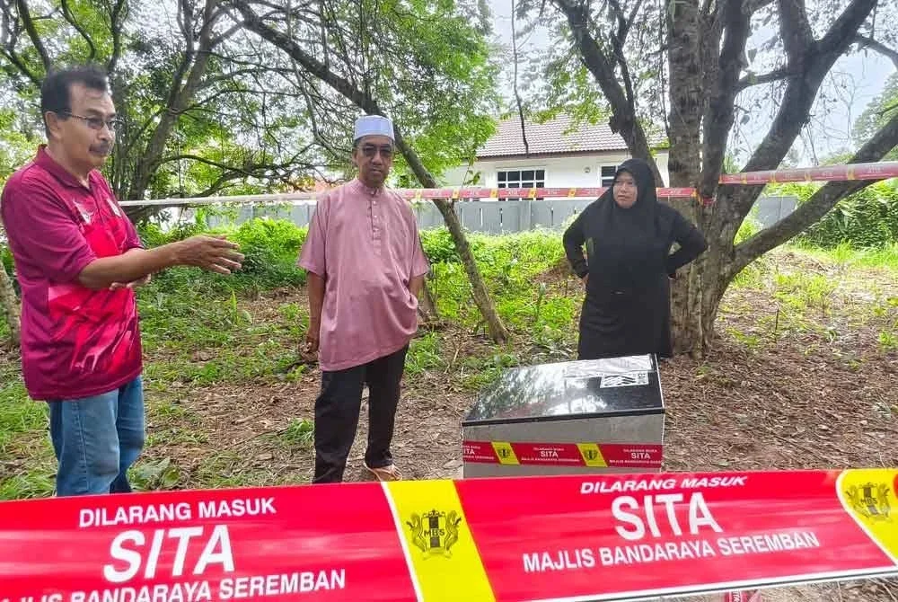 Abdul Rahim (kiri) dan Sahat (tengah) melihat lokasi pembinaan tanda tugu di Bandar Tasik Senangin, Seremban pada Jumaat.