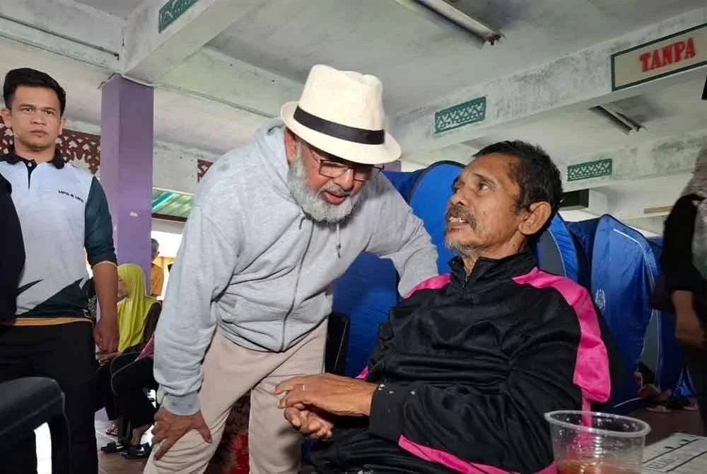 Syed Abu Hussin menyantuni mangsa banjir ketika meninjau keadaan PPS SK Simpang pada Jumaat.
