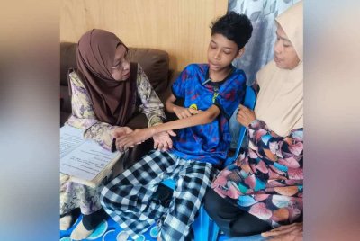 Zuraini (kiri) melihat benjolan yang muncul di lengan kiri Muhammad Irsyad Azim.