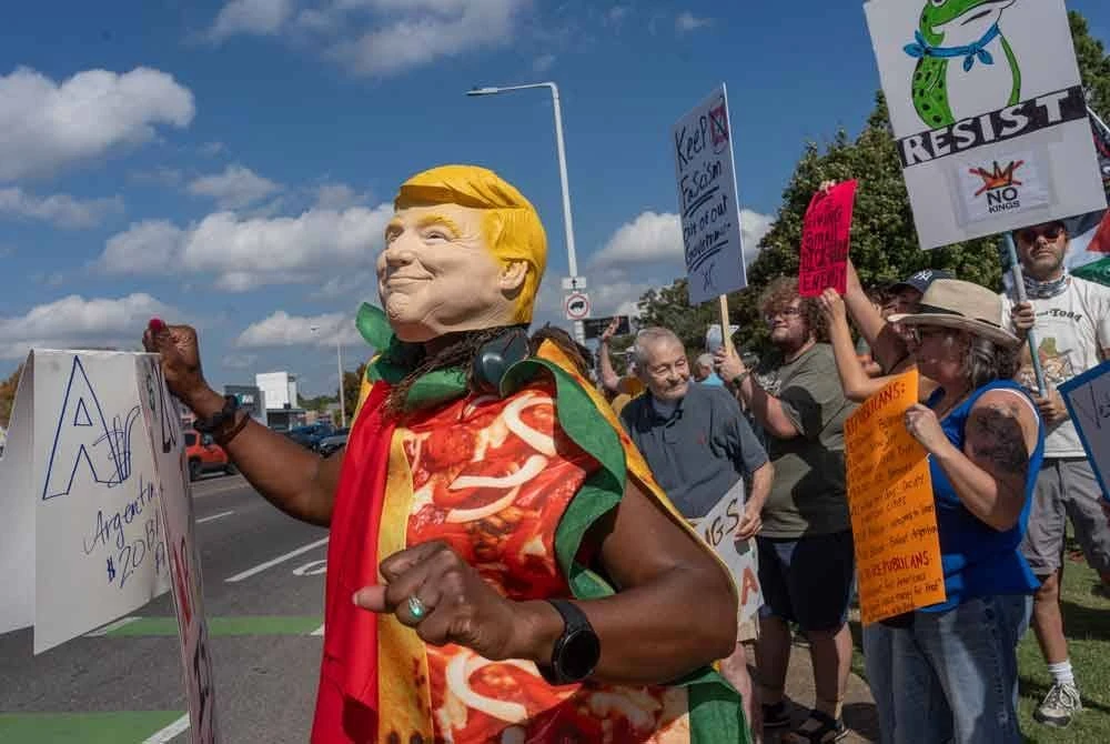 Seorang penunjuk perasaan memakai kostum menyerupai Donald Trump di Memphis, Tennessee.