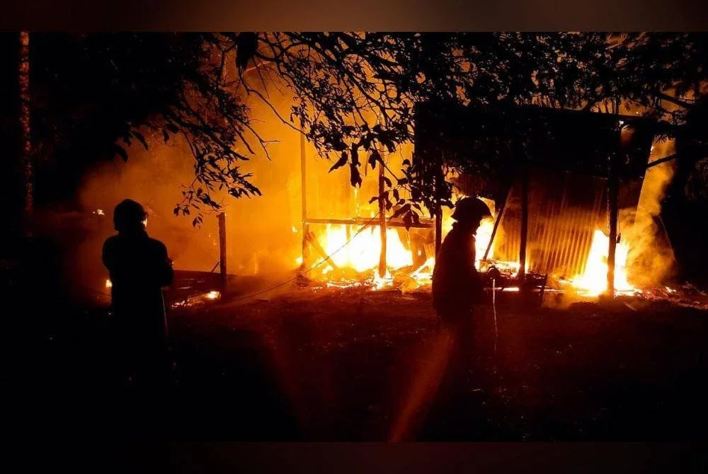 Anggota bomba memadamkan kebakaran rumah di Kampung Bangkahak Sunsum, Kota Belud. Foto Bomba