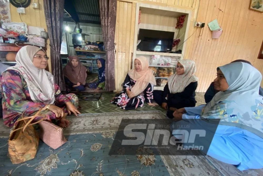 Wan Salma (kiri) menceritakan semula detik-detik cemas yang dilalui kepada saudara mara di rumahnya di Kampung Kok Bedollah, Tumpat pada Sabtu. Foto SINAR HARIAN/HAZELEN LIANA KAMARUDIN