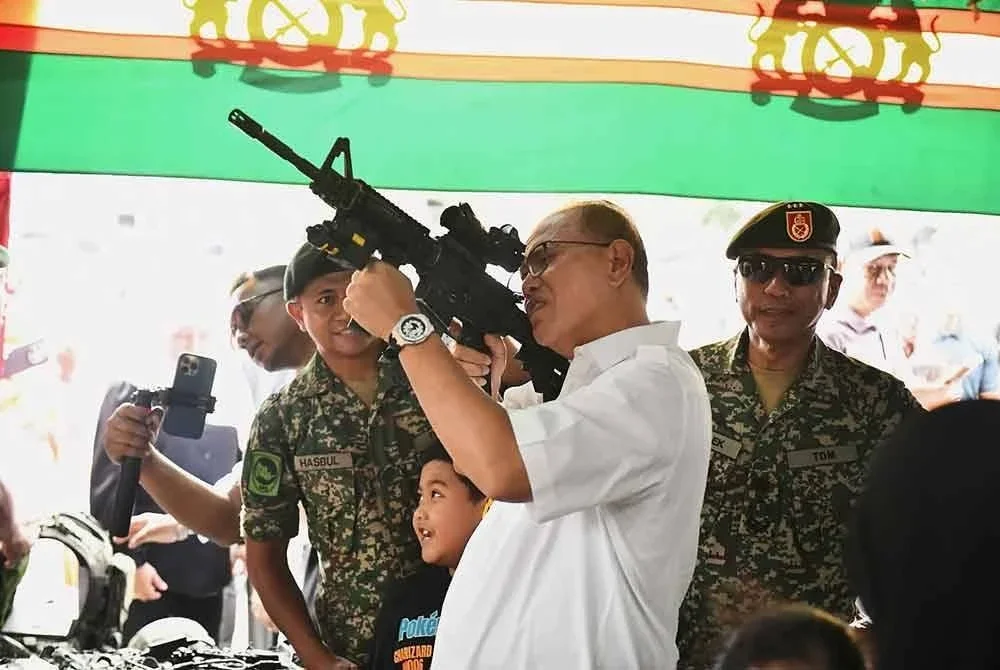 Wan Rosdy tidak ketinggalan mencuba senjata api yang dipamerkan dalam program Program Jelajah Wira Madani dan Satelit Madani Rakyat Tahun 2025 Warga Felda Sungai Koyan. Foto FB Wan Rosdy