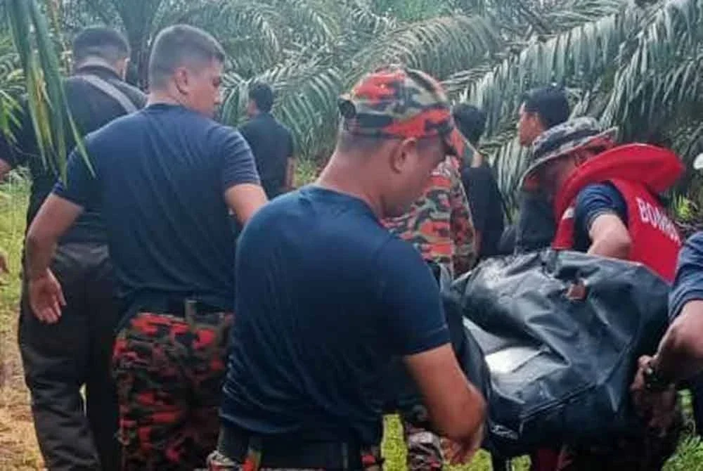 Anggota bomba mengangkat mayat Siti Nur Khadijah di kawasan lombong di Kampung Penchu, Kundang Ulu, Gersik, Tangkak. - Foto JBPM