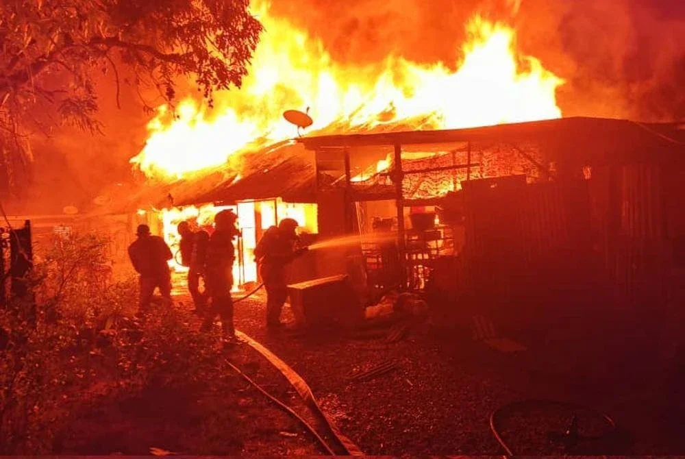 Anggota bomba berusaha memadamkan kebakaran yang memusnahkan enam buah rumah di Jalan Mak Intan, Kampung Terengganu, Teluk Intan tengah malam tadi.