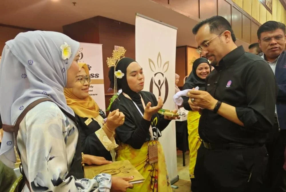 Asyraf Wajdi (kanan) ketika meninjau reruai usahawan wanita sempena Program Pemerkasaan Wanita MARA peringkat negeri Kedah dan Perlis pada Ahad.