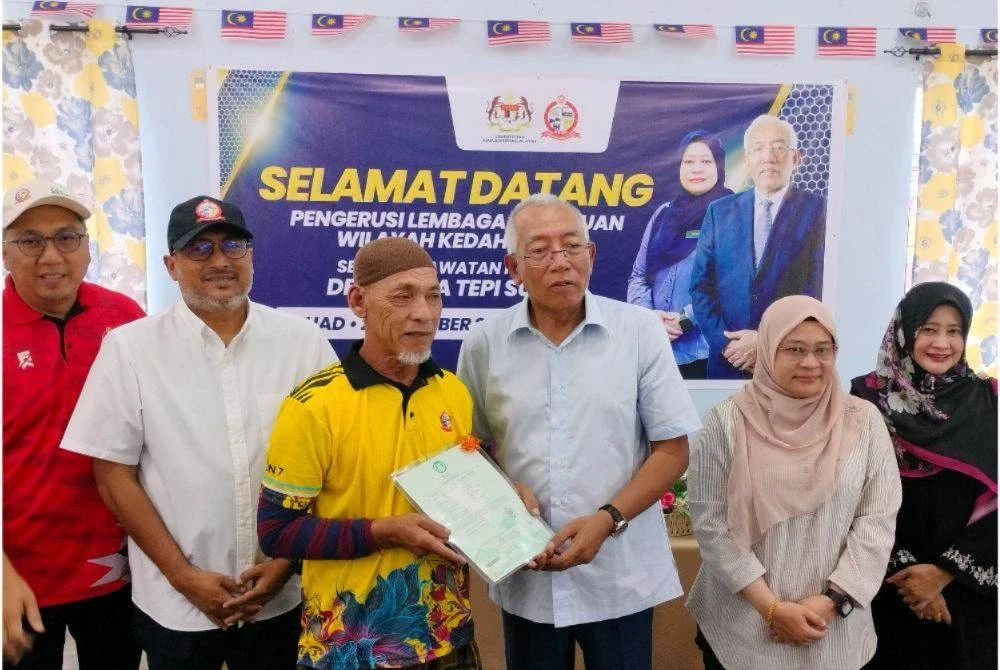 Mahdzir (tiga kanan) menyampaikan sumbangan ketika hadir ke Desa KEDA Tepi Sungai pada Ahad.