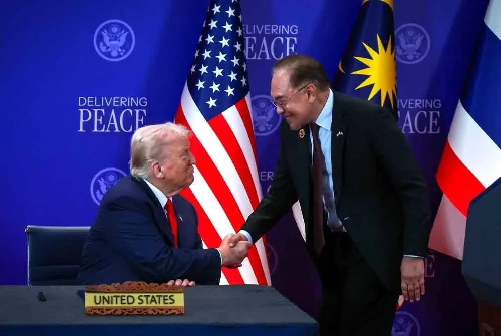 Presiden Amerika Syarikat, Donald Trump, dan Perdana Menteri Malaysia, Datuk Seri Anwar Ibrahim (kanan), berkongsi detik gembira apabila mereka berjabat tangan semasa majlis menandatangani perjanjian damai Kemboja-Thailand pada Sidang Kemuncak ASEAN ke-47 di Pusat Konvensyen Kuala Lumpur pada Ahad. Foto Bernama