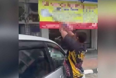 Tangkap layar rakaman video tular memaparkan seorang lelaki bertindak mencabut Jalur Gemilang yang dipasang terbalik dalam kejadian di Pekan Nanas, Pontian.