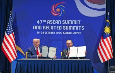Trump dan Anwar menunjukkan dokumen ditandatangani ketika majlis rasmi pemeteraian Perjanjian Perdagangan Timbal Balik AS-Malaysia yang berlangsung sewaktu Sidang Kemuncak ASEAN ke-47 di Kuala Lumpur pada Ahad.