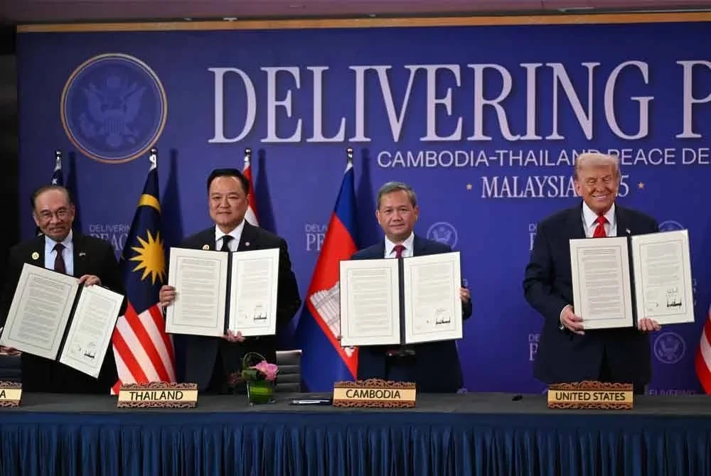 Trump (kanan) dan Anwar (kiri) menyaksikan pertukaran dokumen Perjanjian Damai KL antara Charnvirakul (dua, kiri) dan Manet sempena Sidang Kemuncak ASEAN di KLCC, pada Ahad. Foto AFP