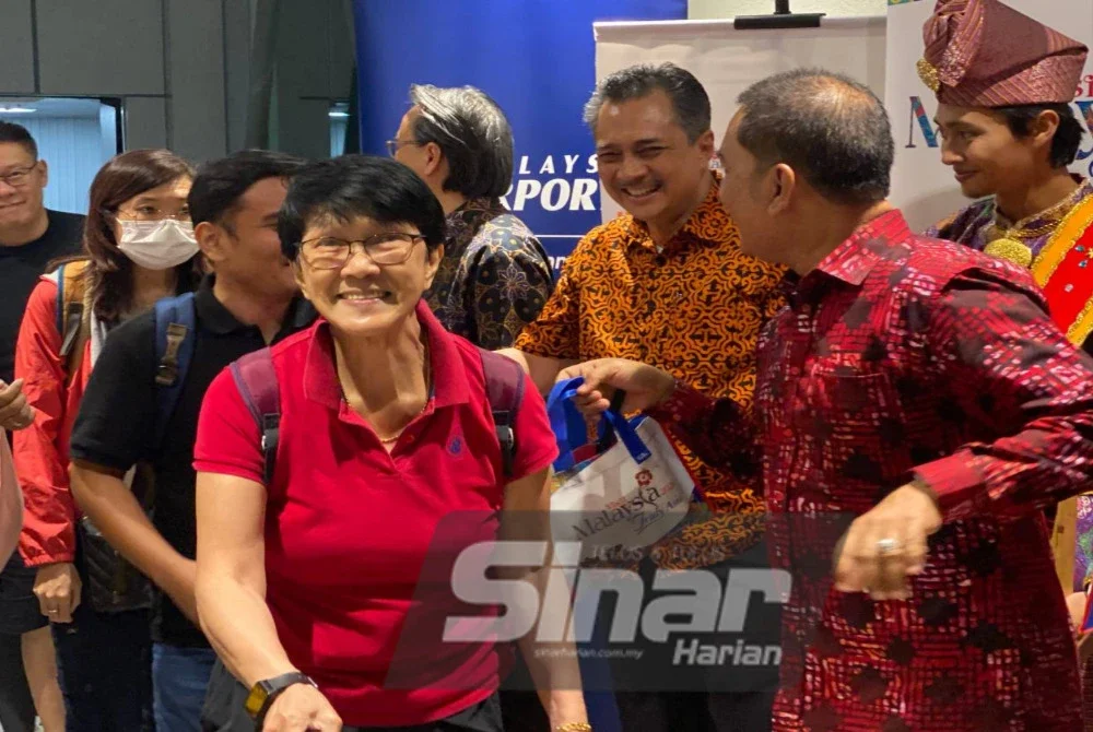 Mohd Izani (dua dari kanan) menyambut ketibaan penumpang penerbangan sulung Scoot dari Singapura ke Kota Bharu di Lapangan Terbang Sultan Ismail Petra, Kota Bharu pada Ahad malam.