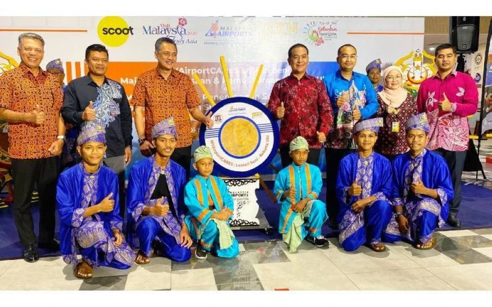 Rosnan (empat, kanan) serta Mohd Izani (tiga,kiri) bersama sebahagian daripada mereka yang hadir pada MYAirportCARES Lestari Seni, Majlis Pemerkasaan dan Pemuliharaan Rebana Ubi dan Sambutan Penerbangan Sulung Scoot di LTSIP, Kota Bharu pada Ahad.
