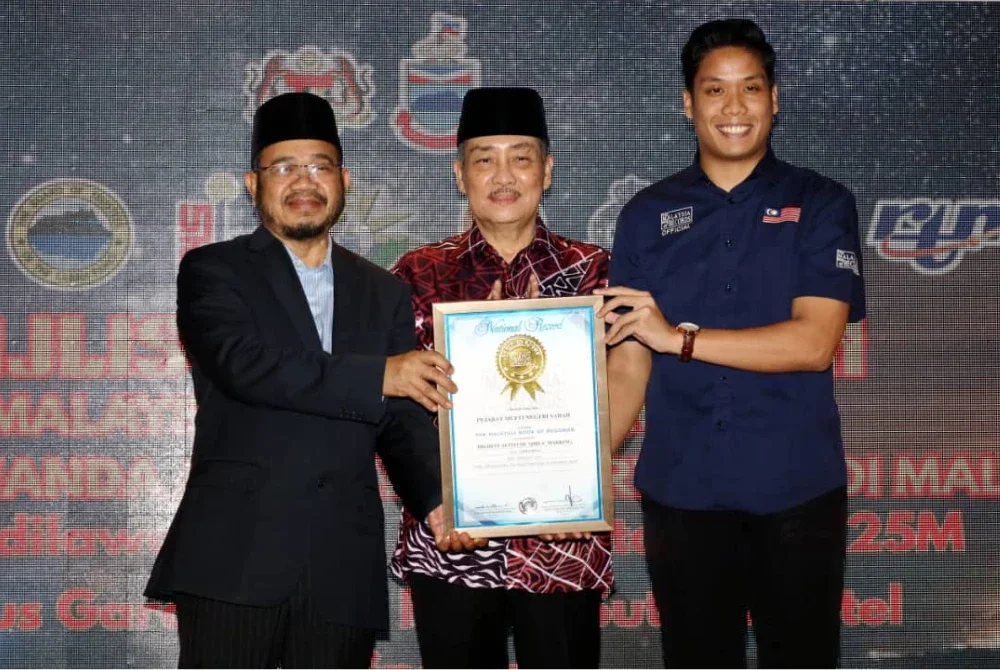 Hajiji (tengah) bersama Mufti Kerajaan Sabah, Datuk Bungsu @ Aziz Jaafar (kiri) menerima sijil pengiktirafan daripada wakil MBOR di Kota Kinabalu pada Isnin.