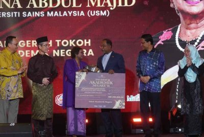 Zambry menyampaikan anugerah kepada Siti Zuraina.