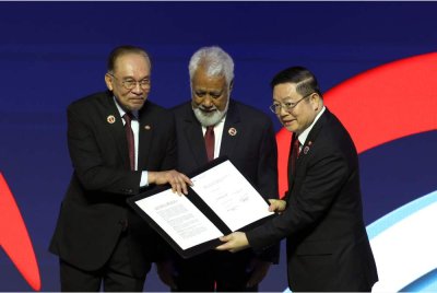 Anwar menyerahkan dokumen Deklarasi Kemasukan Timor-Leste ke ASEAN kepada Setiausaha Agung ASEAN, Dr Kao Kim Hourn (kanan) sambil disaksikan oleh Perdana Menteri Timor-Leste, Kay Rala Xanana Gusmao semasa Majlis Pembukaan Sidang Kemuncak ASEAN ke-47 dan Sidang Kemuncak Berkaitan di Pusat Konvensyen Kuala Lumpur (KLCC) pada Ahad. Foto Bernama