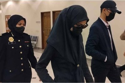 Irfan Syafiq Hafizi dan Nurul Hidayatul Asyikin diiringi pegawai SPRM keluar dari mahkamah selepas selesai sebutan kes mereka di Mahkamah Sesyen pada Isnin.