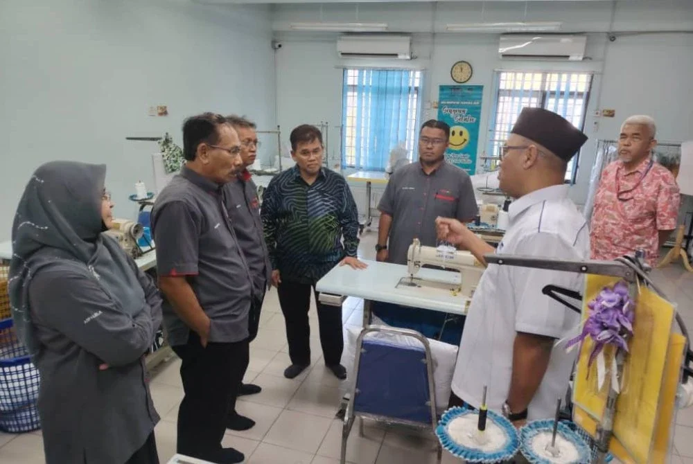 Salehuddin (tengah) meninjau pusat membuat pakaian sekolah Teras di aras dua selepas merasmikan program.