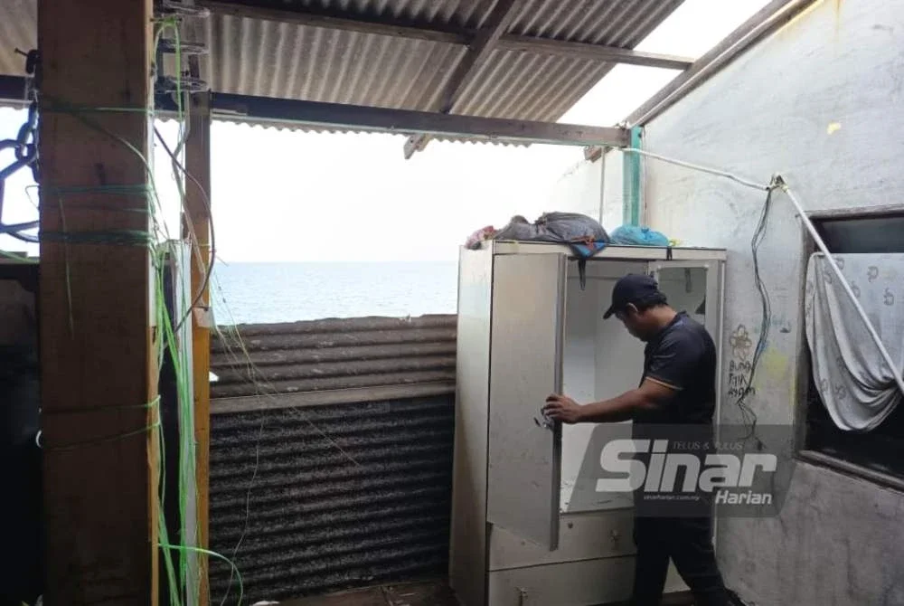 Zamri menunjukkan keadaan rumahnya di Kampung Pantai, Batu Rakit yang rosak akibat hakisan pantai sejak hujung tahun lalu.