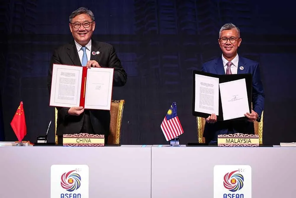 Tengku Zafrul (kanan) dan Wentao menandatangani Protokol Naik Taraf ACFTA 3.0. hari ini. Foto Bernama