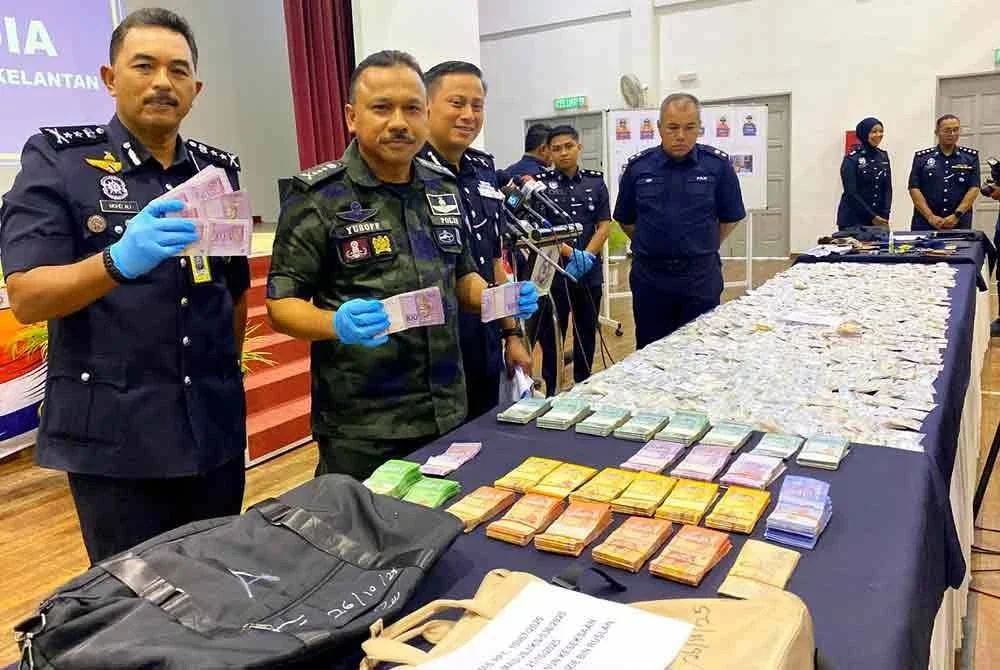 Mohd Yusoff (dua dari kiri) menunjukkan wang yang dirampas ketika sidang akhbar di IPD Pasir Mas pada Selasa. Foto:SINAR HARIAN/HAZELEN LIANA KAMARUDIN
