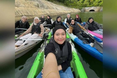 Nur Izzaty (kanan) melakukan aktiviti kayak bersama rakan-rakannya.