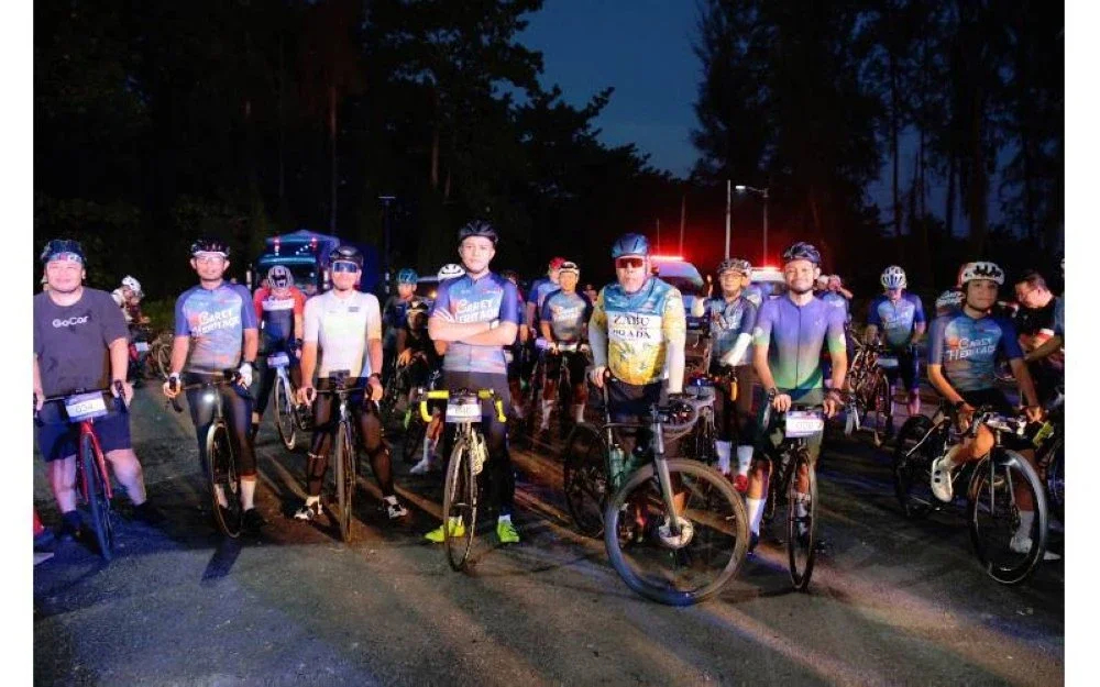 Mohamad Helmy (tengah) bergambar bersama peserta yang menyertai kayuhan sejauh 100 km berkenaan.