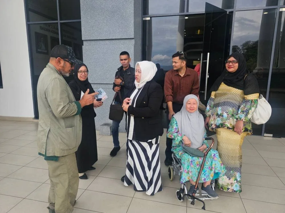 Ahli keluarga Allahyarham Leftenan Kolonel Mohd Zahir bersama pasukan peguam yang mewakili mereka di pekarangan Kompleks Mahkamah Kota Kinabalu pada Rabu.