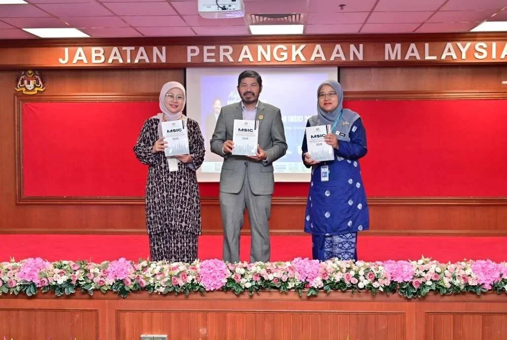 Mohd Uzir (tengah) menunjukkan buku MSIC 2025 yang dilancarkan pada Selasa.