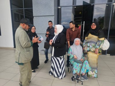 Ahli keluarga Allahyarham Leftenan Kolonel Mohd Zahir bersama pasukan peguam yang mewakili mereka di pekarangan Kompleks Mahkamah Kota Kinabalu pada Rabu. 