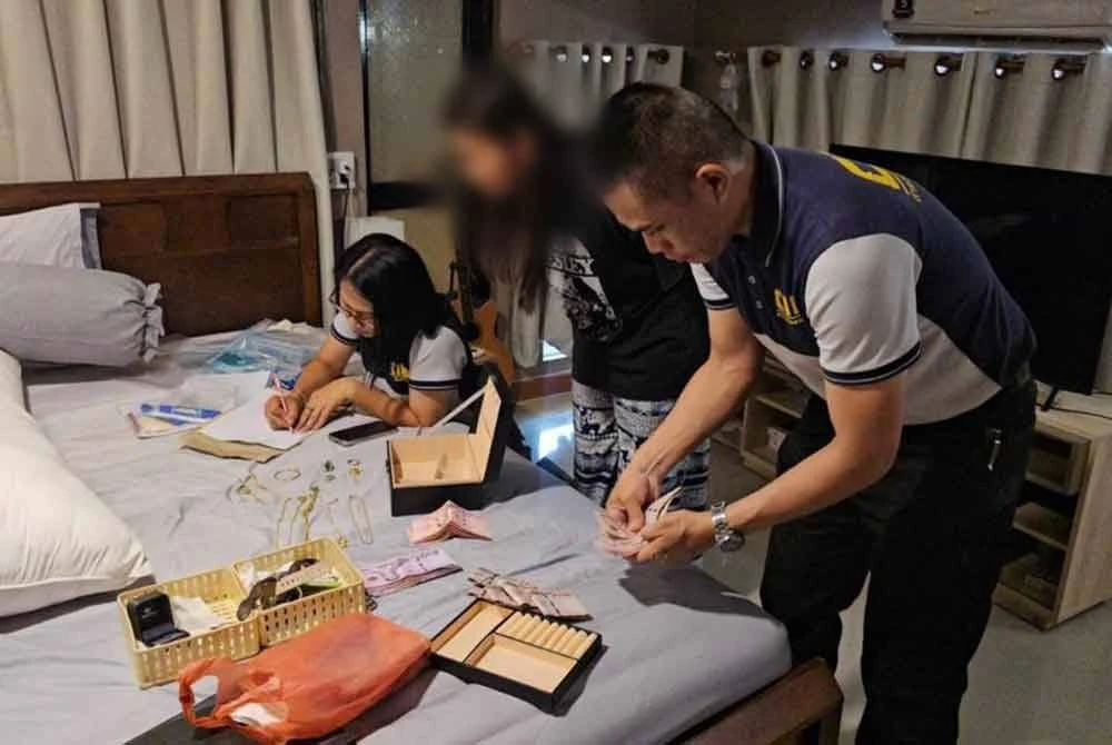 Polis merampas pelbagai barangan ketika serbuan dilakukan di sebuah hotel di Bangkok. Foto Khaosod