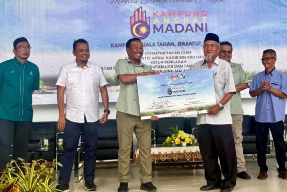Abdul Kadir (tiga dari kiri) menyerahkan sumbangan kepada Masjid Kampung Kuala Tahan sempena Program Penyerahan Projek Kampung Angkat Madani Tahun 2025 di Kompleks Letak Kereta Kuala Tahan, Jerantut pada Khamis.