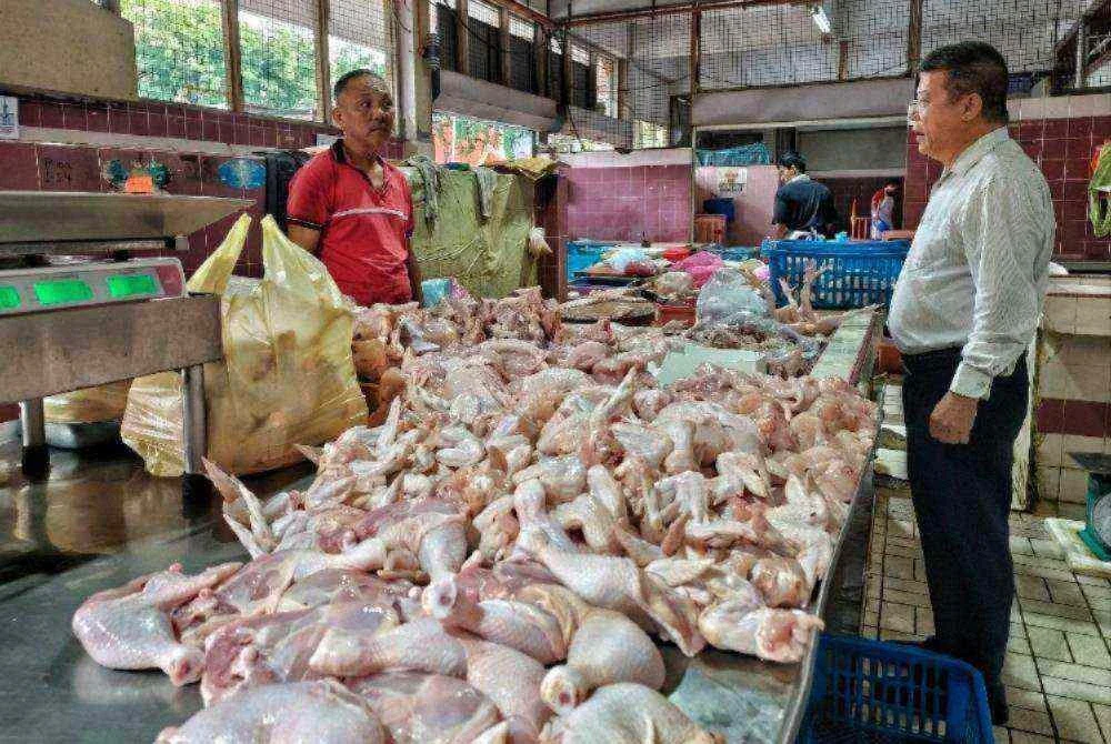 Chon Siang (kanan) berinteraksi dengan peniaga ayam ketika
pemantauan operasi perniagaan Pasar Besar Kuantan di sini pada Khamis.
