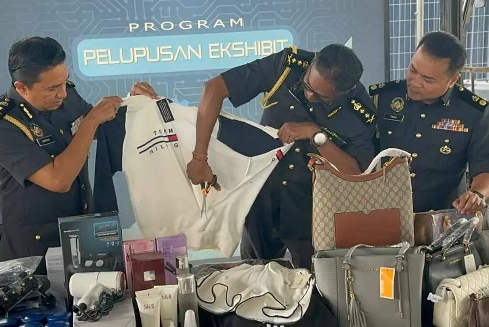 Jegan (tengah) melupuskan barang kes di Kompleks Penyimpanan Ekshibit KPDN Pulau Pinang pada Khamis.