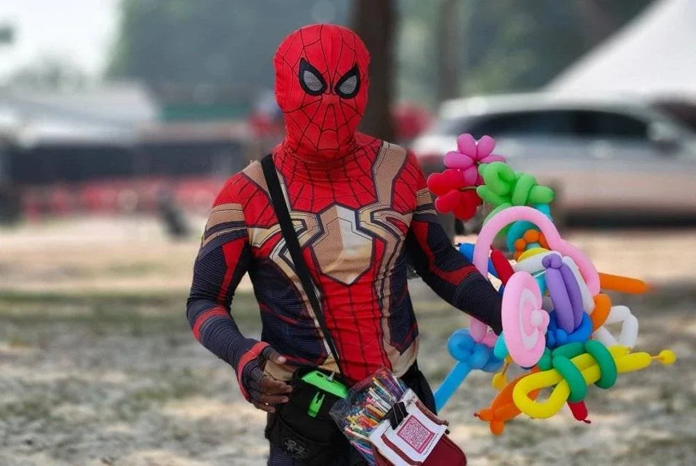 Mohd Khairul Anwar memakai kostum Spiderman ketika menjual belon badut untuk mengumpul duit hantaran kahwin.