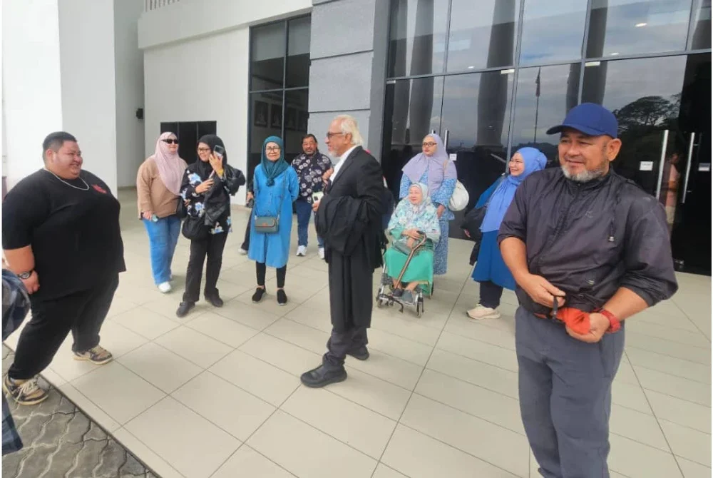 Ansari (tengah) bersama ahli keluarga Allahyarham Mohd Zahir di pekarangan Kompleks Mahkamah Kota Kinabalu.