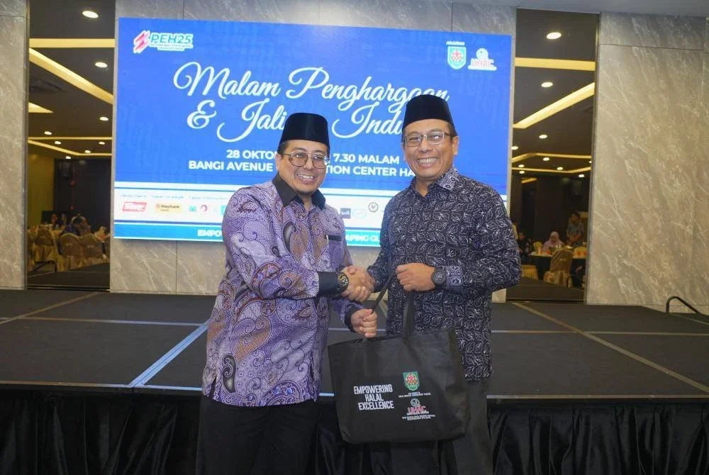 AMIR HAMZAH (kanan) menyampaikan cenderamata kepada Mohd Shahril.