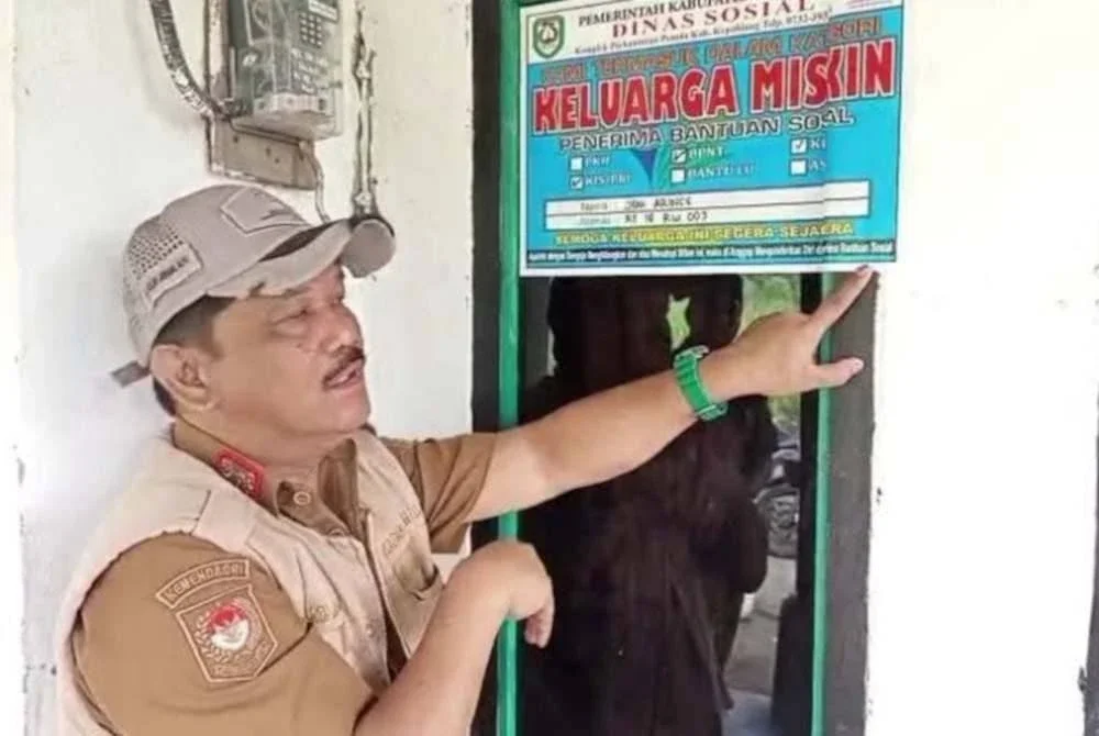 Ketua Jabatan Kebajikan Sosial Daerah Kepahiang, Helmi Johan, menampal pelekat 'Keluarga Miskin' pada rumah penerima bantuan sosial kerajaan. Agensi