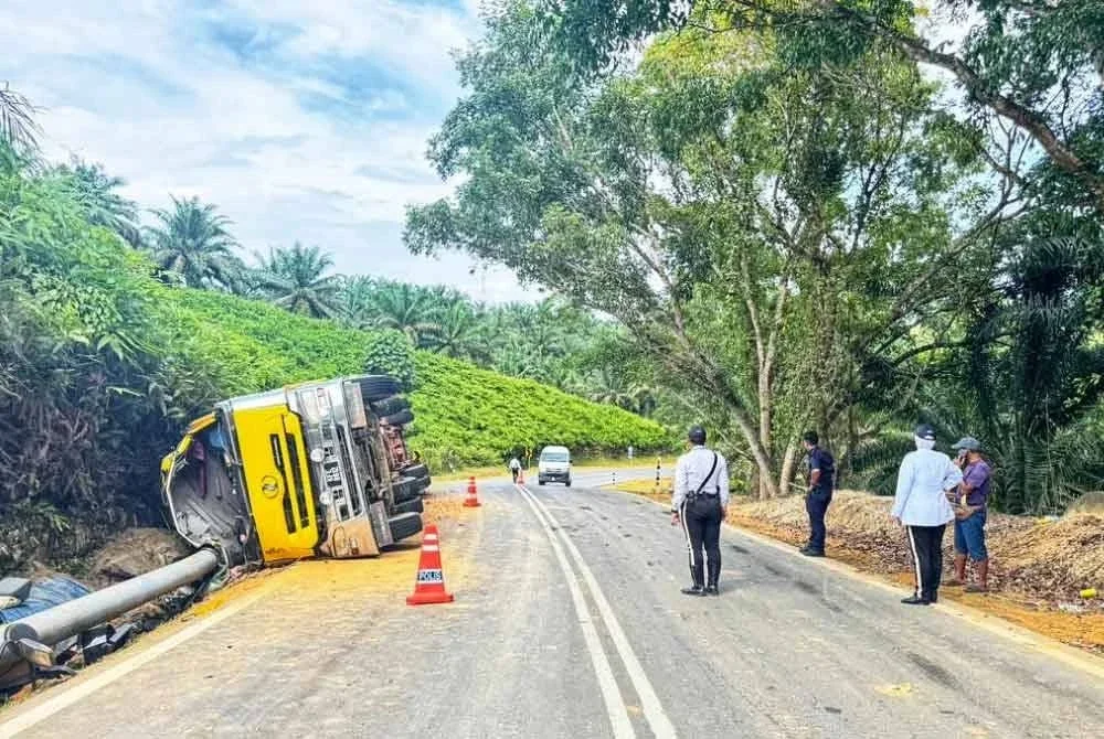 Treler yang membawa muatan balak dipercayai hilang kawalan dan terbalik.