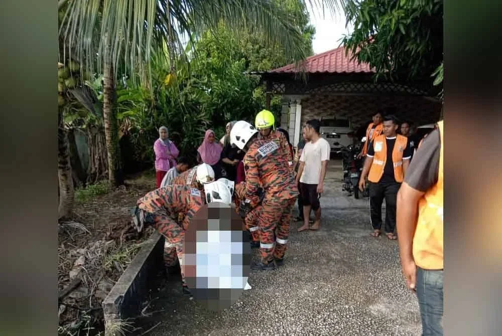 Anggota bomba mengangkat mayat mangsa yang tercampak ke dalam parit.