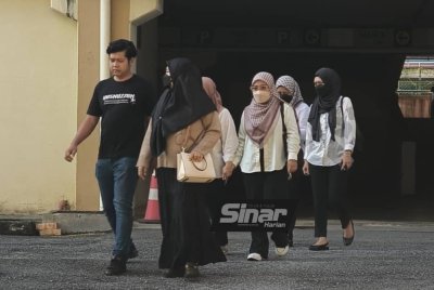 Ismanira (depan kanan) ditemani suaminya, Zaim Ikhwan (depan kiri) ketika tiba di kompleks Mahkamah Petaling Jaya pada Jumaat.
