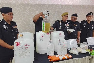 Noor Hisam (tengah) menunjukkan antara barangan yang dirampas dalam serbuan anggota JSJN IPK Perak di sebuah rumah di Taman Assamara, Taiping pada Rabu lalu.